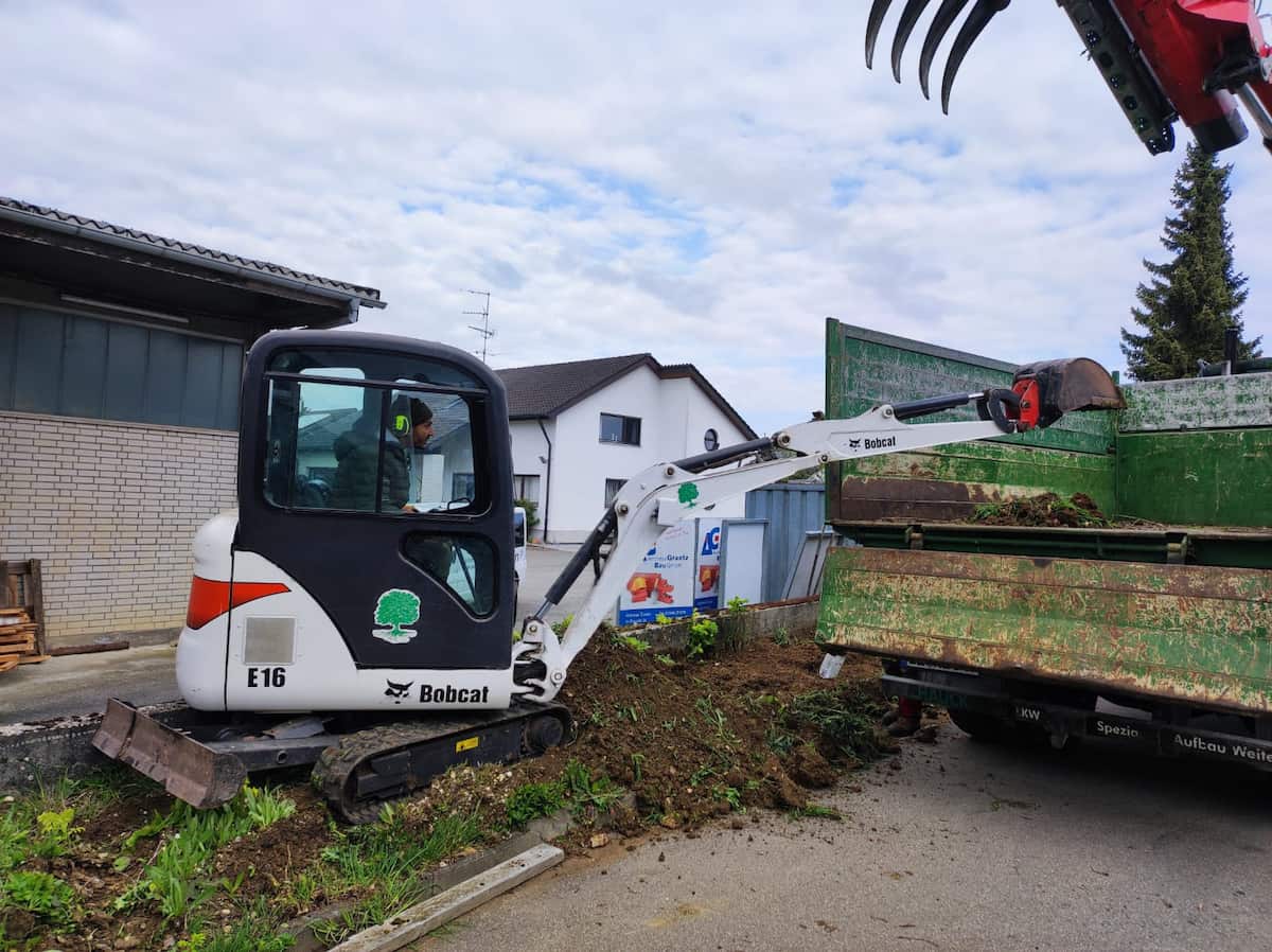 Minibagger planiert eine Gartenfläche